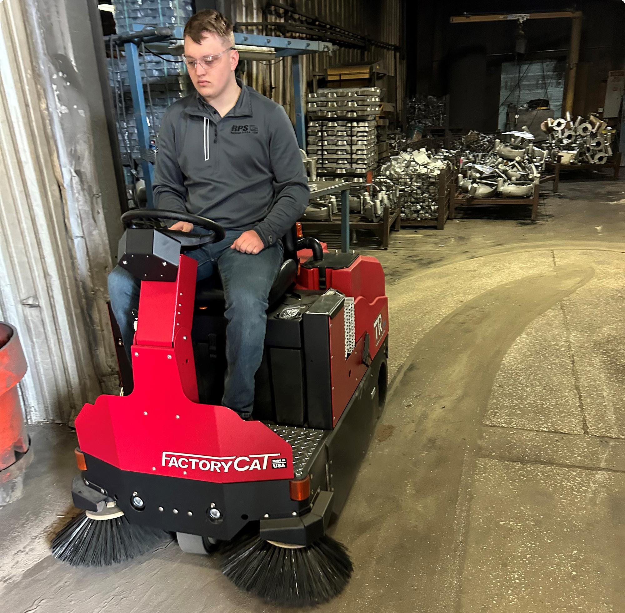 FactoryCat TR ride on floor sweeper sweeping a filthy concrete floor at a die caster IMG0009