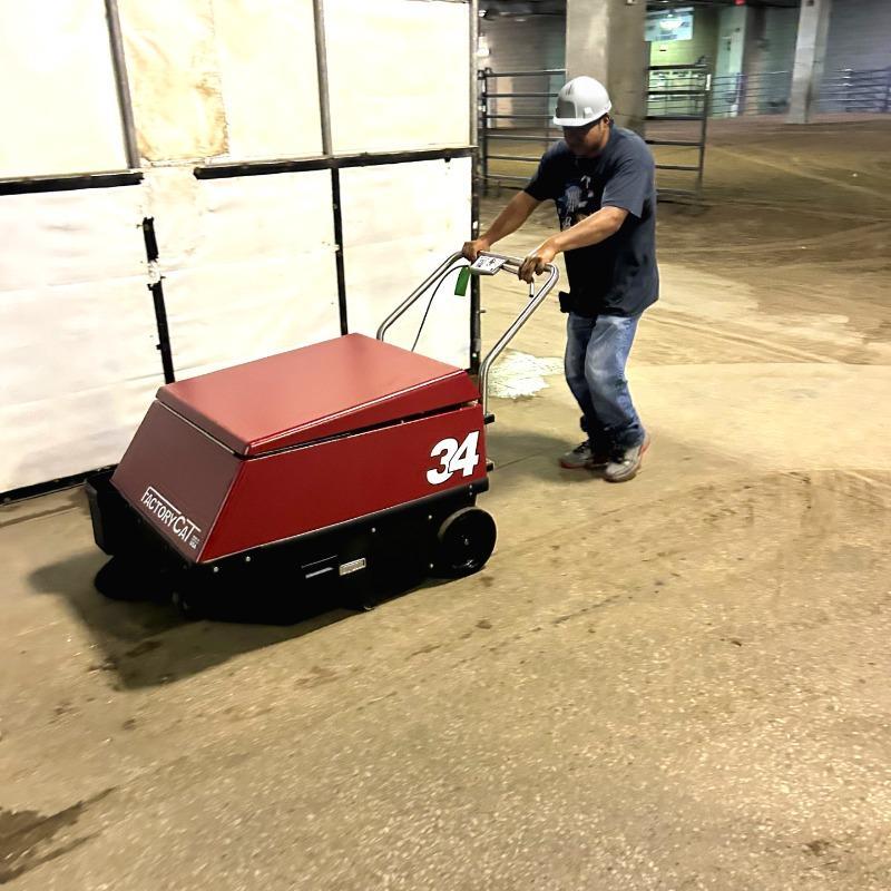 FactoryCat Walk Behind Floor Sweepers 34 service bay concrete - https://assets.factorycat.com/demoImages/2025/april/34-Walk Behind Floor Sweepers-service bay-concrete-Kansas City-USA-488.jpg - 800 - 800 - 488 A FactoryCat 34 walk behind battery floor sweeper cleaning the concrete floor of holding pens in Kansas City, MO