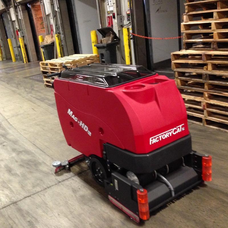 FactoryCat Walk Behind Floor Scrubbers Mag-HD aisles concrete - https://assets.factorycat.com/demoImages/2025/april/Mag-HD-Walk Behind Floor Scrubbers-aisles-concrete-Dallas -USA-803.jpg - 800 - 800 - 803 A FactoryCat Mag-HD Walk Behind Floor Scrubber is cleaning the concrete aisles of a Dallas, Texas warehouse club