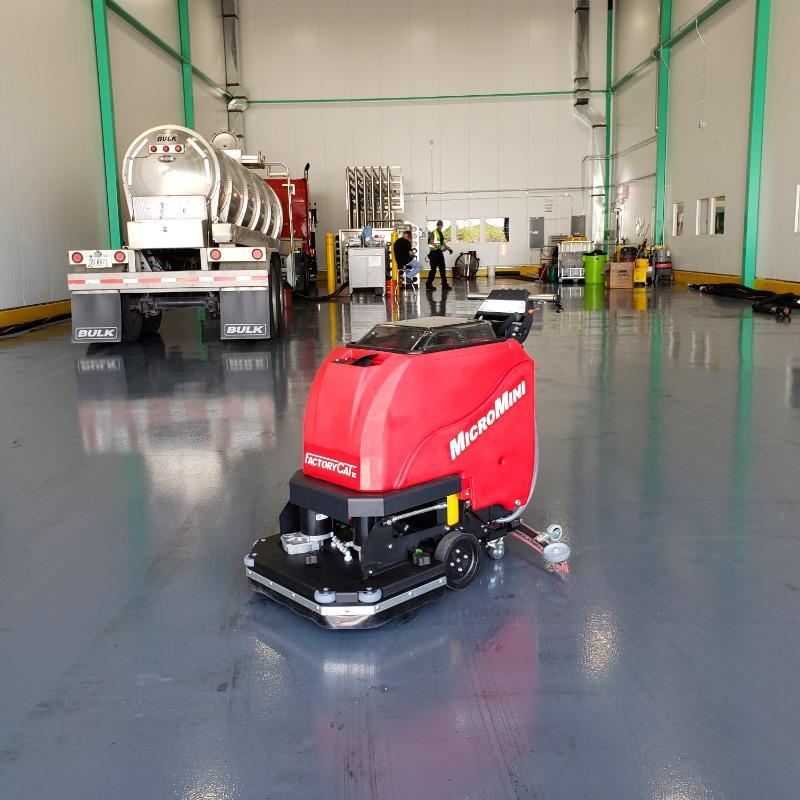 FactoryCat Walk Behind Floor Scrubbers MicroMini service bay concrete - https://assets.factorycat.com/demoImages/2025/april/MicroMini-Walk Behind Floor Scrubbers-service bay-concrete-Knoxville-USA-303.jpg - 800 - 800 - 303 A MicroMini battery floor scrubber cleans epoxy-coated concrete floors in a service area of a manufacturing plant in TN.