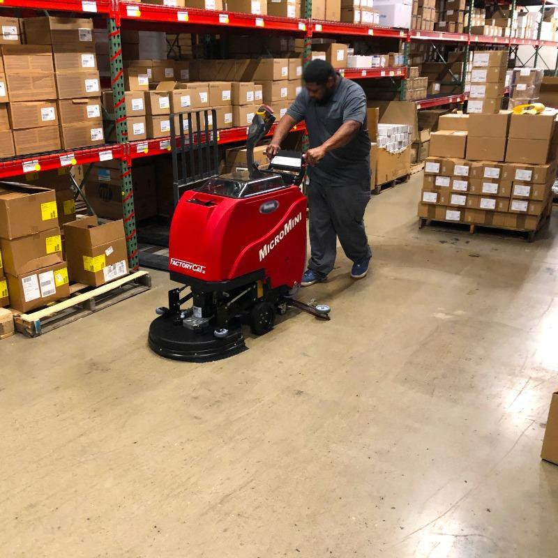 FactoryCat Walk Behind Floor Scrubbers MicroMini warehouse concrete - https://assets.factorycat.com/demoImages/2025/april/MicroMini-Walk Behind Floor Scrubbers-warehouse-concrete-lPONG bEACH-USA-854.jpg - 800 - 800 - 854 A FactoryCat MicroMini Walk Behind Floor Scrubber cleaning the concrete floor of a warehouse of a Long beach, California contract manufacturer