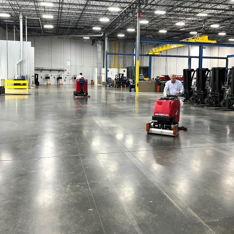 FactoryCat Walk Behind Floor Scrubbers Mini-HD warehouse concrete - https://assets.factorycat.com/demoImages/2025/april/Mini-HD-Walk Behind Floor Scrubbers-warehouse-concrete-Charlotte-USA-485.jpg - 800 - 800 - 485 A FactoryCat Mini-HD battery walk behind floor scrubber cleaning the concrete floor of a warehouse in Charlotte, NC