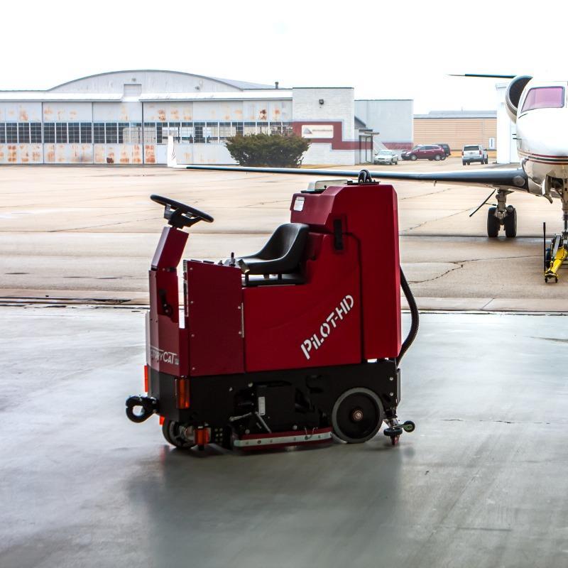 FactoryCat Ride On Floor Scrubbers Pilot hangar epoxy - https://assets.factorycat.com/demoImages/2025/april/Pilot-Ride On Floor Scrubbers-hangar-epoxy-Birmingham-USA-838.jpg - 800 - 800 - 838 A FactoryCat Pilot Ride On Floor Scrubber cleans the epoxy floor on a Birmingham, Alabama airplane hangar