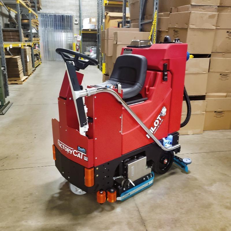 FactoryCat Ride On Floor Scrubbers Pilot warehouse concrete - https://assets.factorycat.com/demoImages/2025/april/Pilot-Ride On Floor Scrubbers-warehouse-concrete-Toldeo-USA-835.jpg - 800 - 800 - 835 A FactoryCat Pilot Ride On Floor Scrubber cleans the concrete floor in a warehouse of a Toledo, Ohio cannery