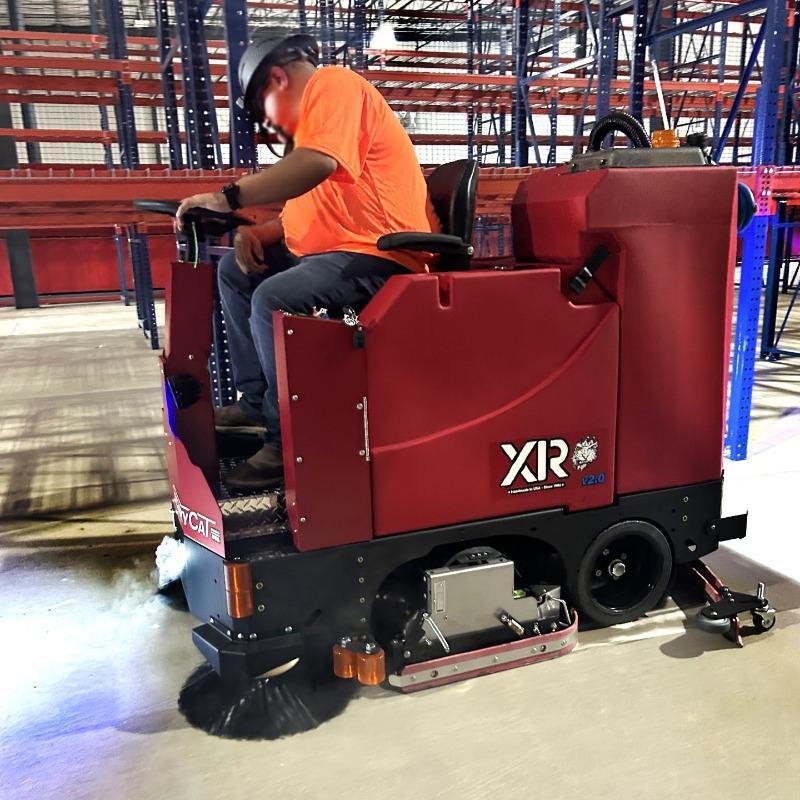 FactoryCat Ride On Floor Scrubbers XR warehouse concrete - https://assets.factorycat.com/demoImages/2025/april/XR-Ride On Floor Scrubbers-warehouse-concrete-Springfield-USA-465.jpg - 800 - 800 - 465 A FactoryCat XR battery floor scrubber cleaning the concrete floor of a warehouse at a 3PL in Springfield, MO